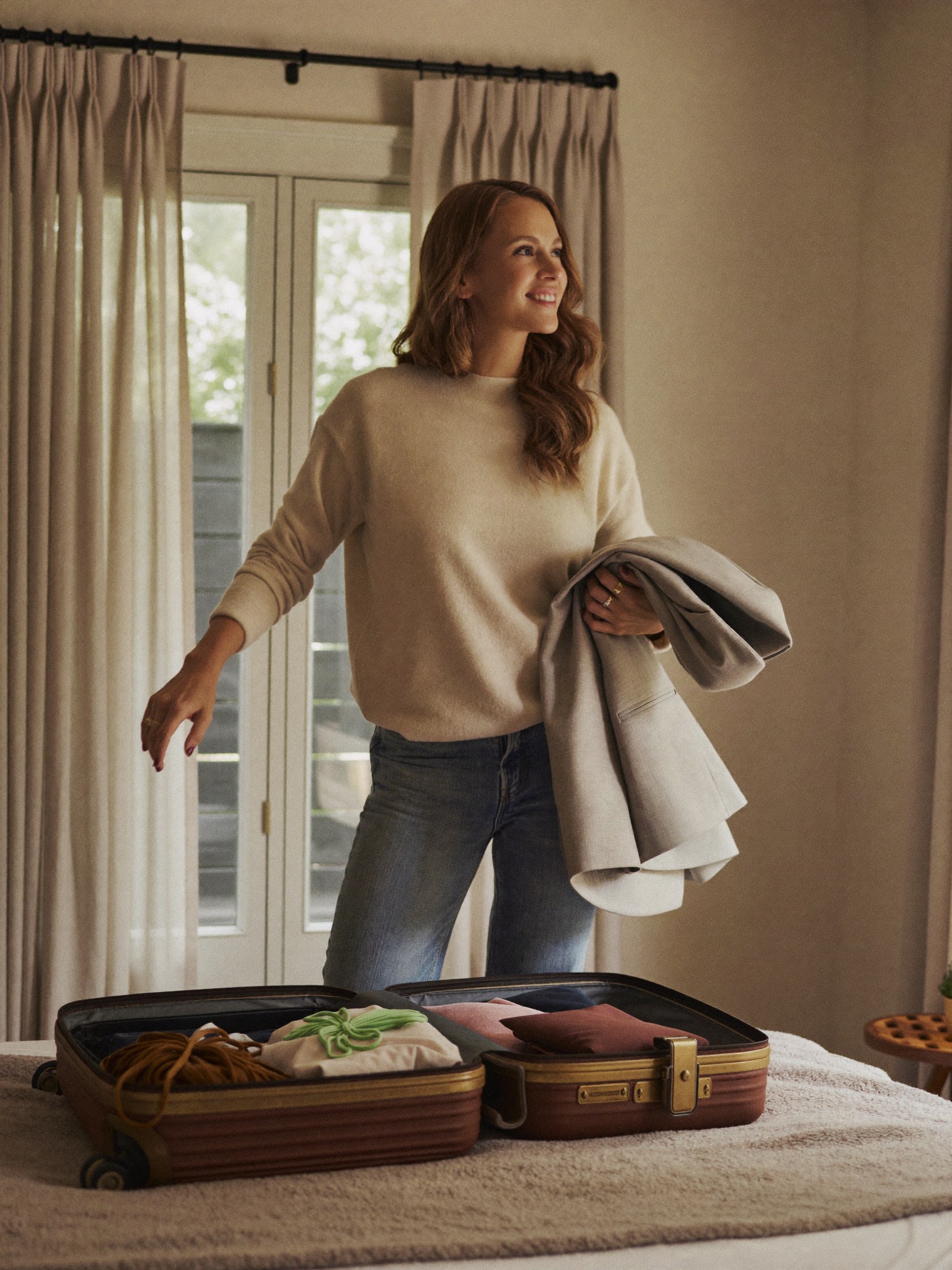 A confident mother packing for her trip, ready to travel for her mommy makeover